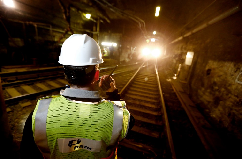 A Port Authority work on the Trans-Hudson train line, talks on a radio as a PATH train approaches in the tunnel, on Nov. 27, 2012, in Hoboken, N.J.