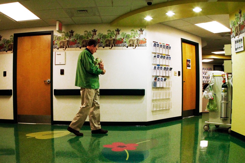A volunteer cuddler walks the hallway with a baby at East Tennessee Children's Hospital in Knoxville. The baby is one of many infants born dependent on drugs being treated at the facility, March 29, 2013.