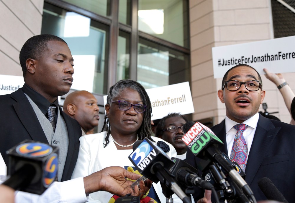 Willie and Georgia Ferrell listen as their attorney, Christopher Chestnut, talks with reporters about the mistrial in the case of Charlotte policeman Wes Kerrick accused of killing their brother and son, Jonathan, Aug. 21, 2015. (Photo by Bob Leverone/AP)