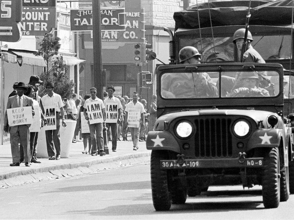 File Photo: Tennessee National Guard troopers in jeeps and trucks escort a protest march by striking Memphis sanitation workers through downtown Memphis Saturday afternoon March 30, 1968. (AP Photo, File)