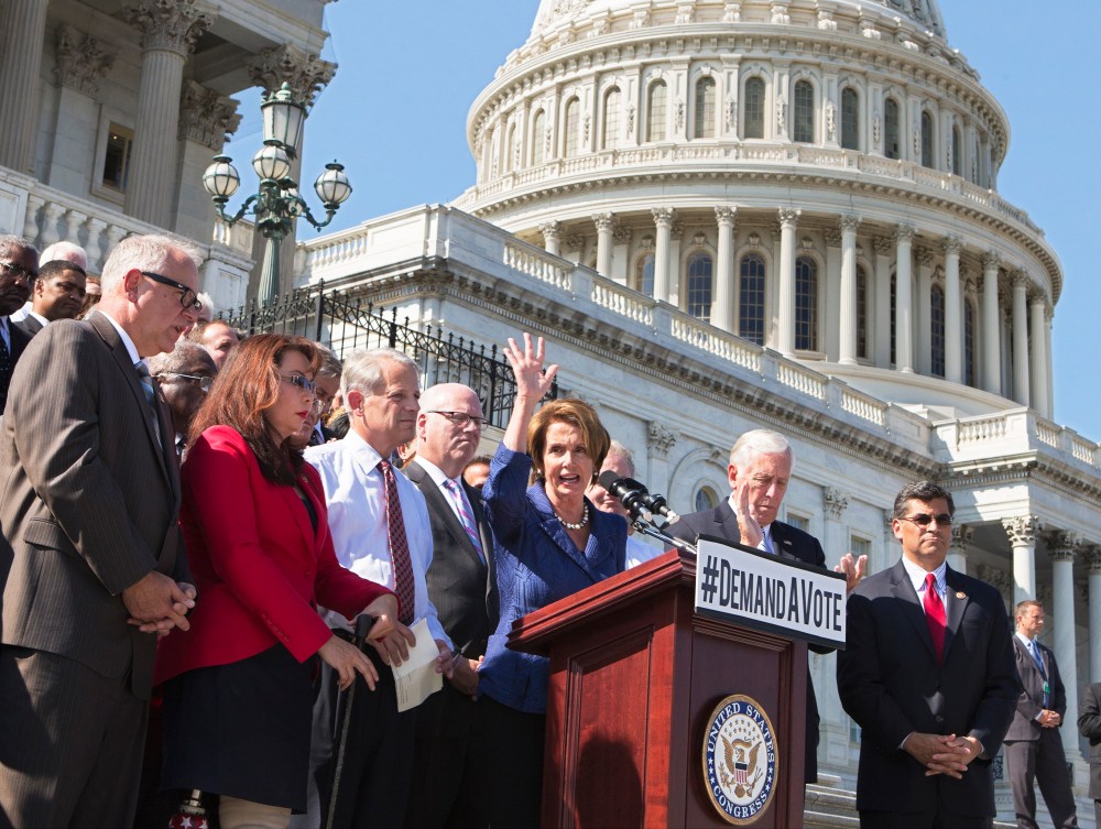 House Democrats rally behind Minority Leader Nancy Pelosi, at the Capitol in Washington, Wednesday, Oct. 2, 2013.