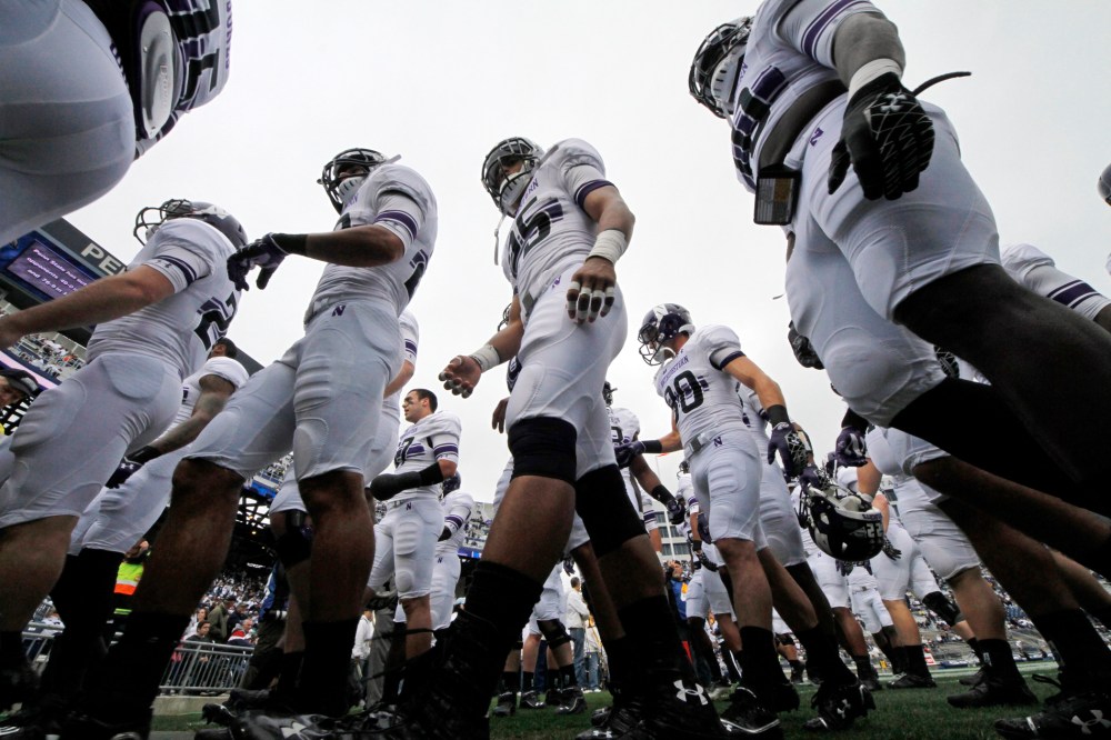 The Northwestern football team heads to the locker room after warming up before an NCAA college football game against Penn State in State College, Pa, Oct. 6, 2012.