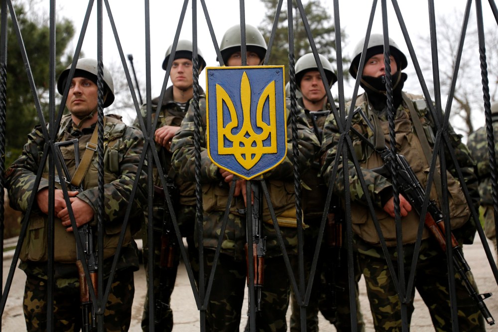 Ukrainian soldiers guard a gate of an infantry base that was surrounded by hundreds of unidentified soldiers, March 2, 2014, in Privolnoye, Ukraine.