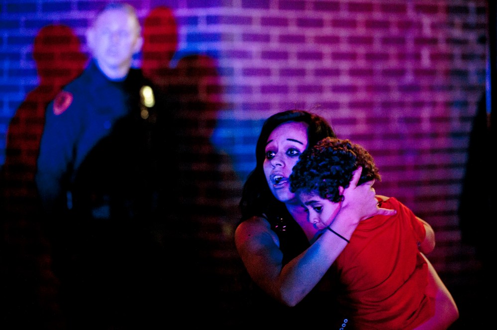 A woman holds a young boy as a crowd of people clash with police following an officer-involved shooting at 200 South Rio Grande Street in Salt Lake City, Feb. 27, 2016. (Photo by Lennie Mahler/The Salt Lake Tribune/AP)