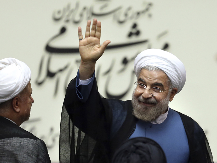 Iran's new President Hasan Rouhani, waves after swearing in at the parliament, in Tehran, Iran, Sunday, Aug. 4, 2013.  (Photo by Ebrahim Noroozi/AP)