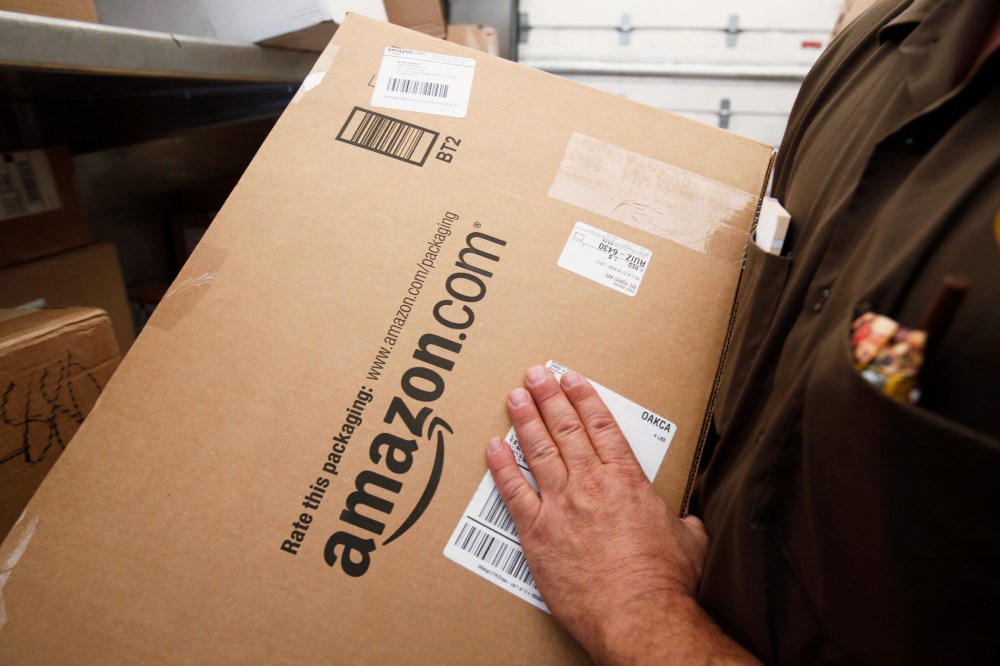 In this Oct. 18, 2010 file photo, a United Parcel Service (UPS) driver lifts an Amazon.com box in Palo Alto, Calif.