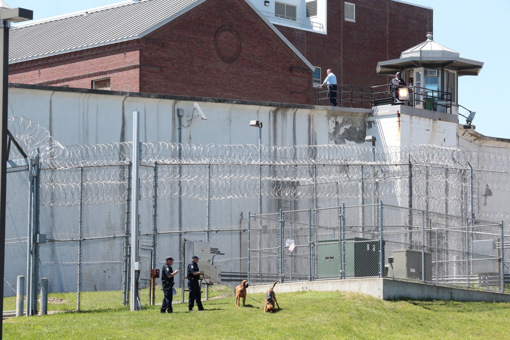 Law enforcement officers with bloodhounds stand guard at one of the entrances to the Clinton Correctional Facility in Dannemora, N.Y. on Saturday, June 6, 2015. (Photo by Gabe Dickens/Press-Republican/AP)