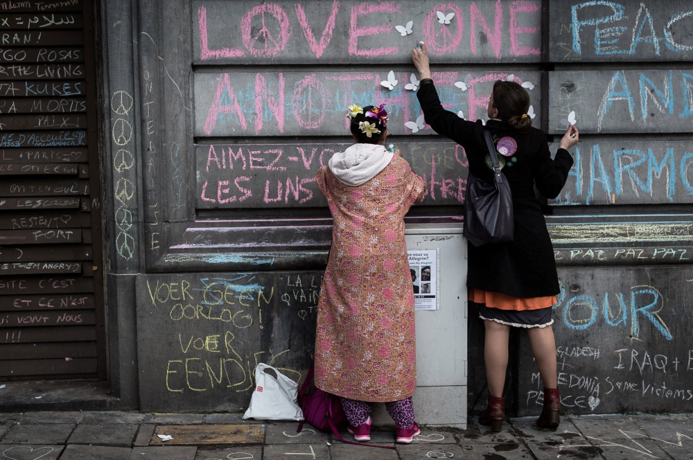 Two children write on a wall at a memorial for victims of attacks in Brussels on March 23, 2016. (Photo by Valentin Bianchi/AP)