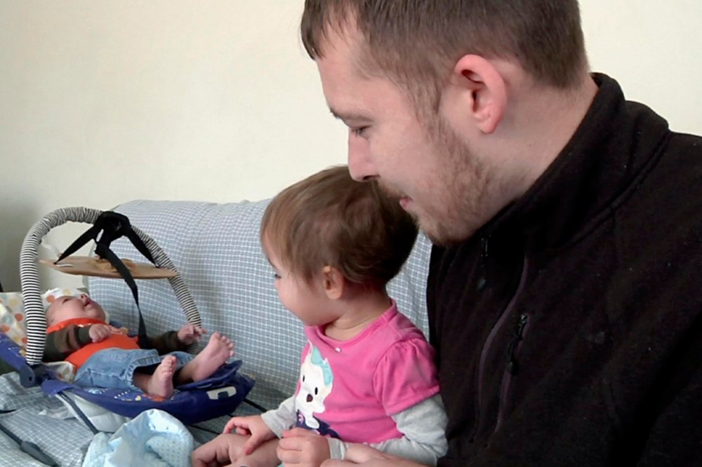 Luke Waid discusses the lead-contamination in Flint's water as he watches his 2-year-old daughter, Sophia, and infant son, Luke Jr, in their Flint, Mich., home. (Photo by Mike Householder/AP)