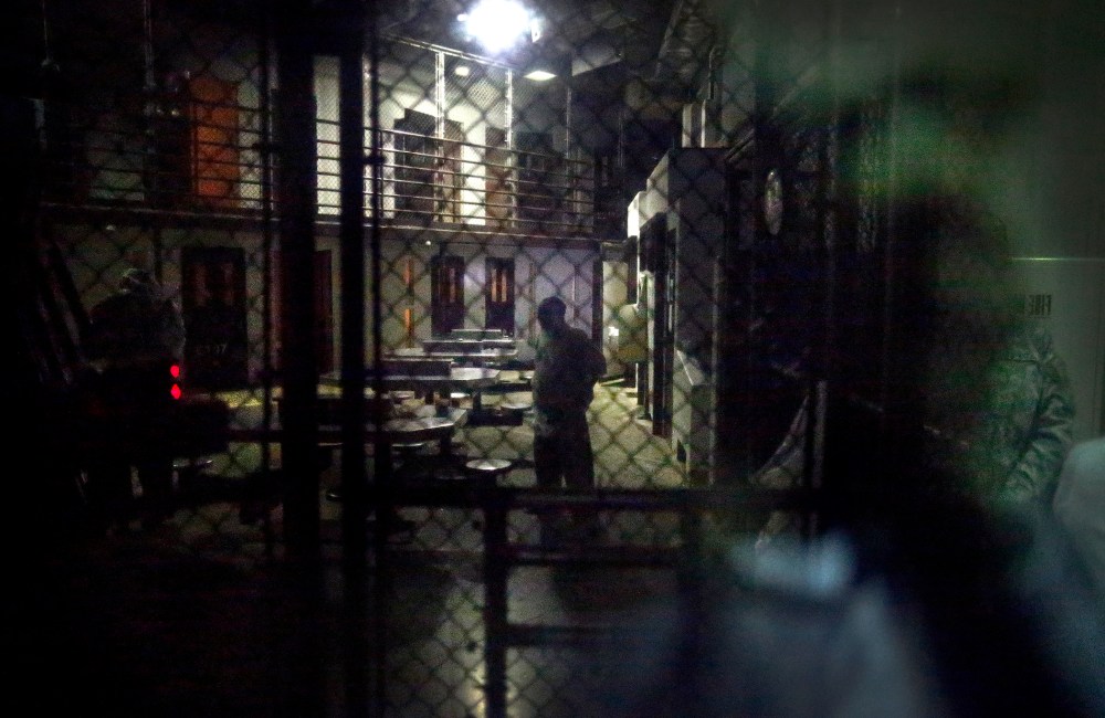 In this photo reviewed by the U.S. military, detainees behind a mirrored one-way window get ready for pre-dawn Islamic prayers in Camp VI detention facility at Guantanamo Bay Naval Base, Cuba, Nov. 20, 2013.