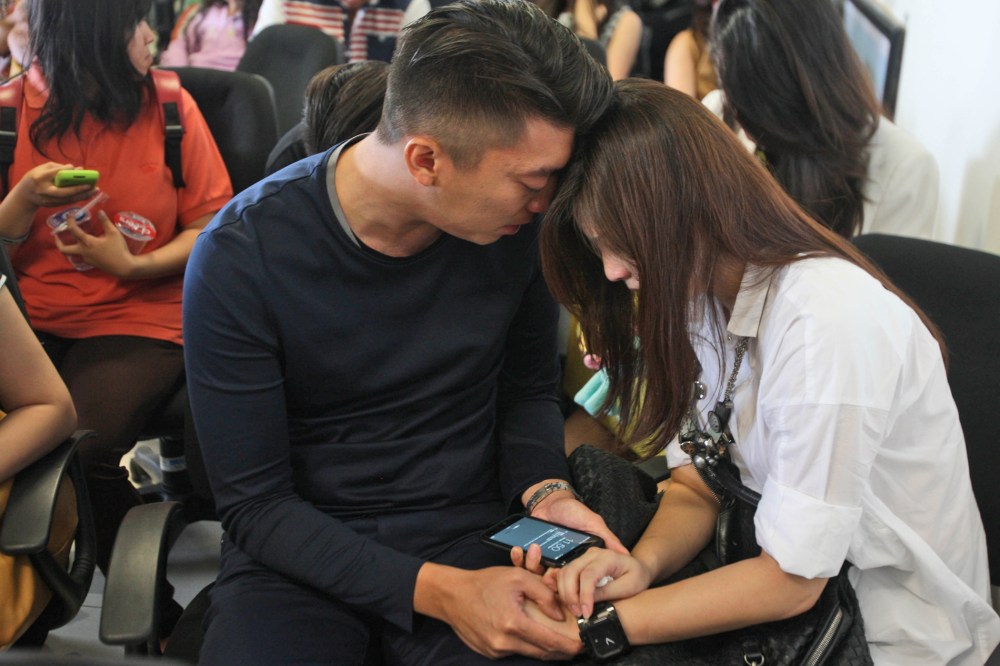 Relatives of the passengers of AirAsia flight QZ8501 comfort each other at Juanda International Airport in Surabaya, East Java, Indonesia, Dec. 28, 2014. (Photo by Trisnadi/AP