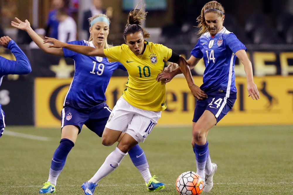 Brazil's Marta (10) works to get to the ball between the United States' Julie Johnston (19) and Morgan Brian (14) during the first half of an international friendly soccer match, Oct. 21, 2015, in Seattle. (Photo by Elaine Thompson/AP)