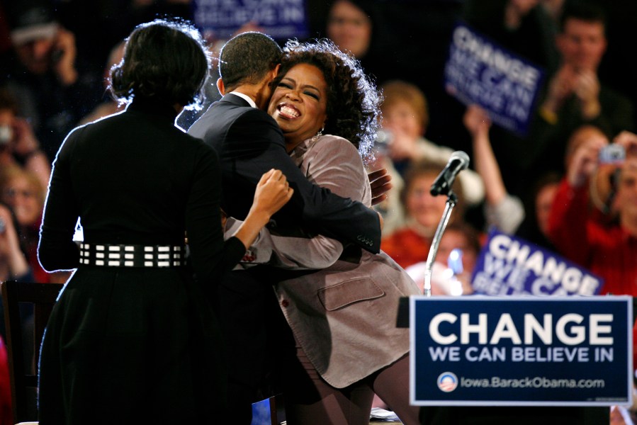 Democratic presidential hopeful, Sen. Barack Obama, D-Ill.. gets a hug from Oprah Winfrey as his wife Michelle, left, looks on during a rally, Dec. 8, 2007, in Des Moines, Iowa. (Photo by Charlie Neibergall/AP)