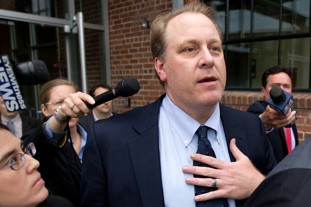 In this May 16, 2012, file photo, former Boston Red Sox pitcher Curt Schilling, center, is followed by members of the media as he departs the Rhode Island Economic Development Corporation headquarters, in Providence, R.I. (Photo by Steven Senne/AP)