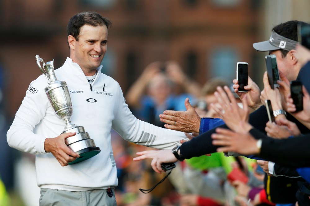 United States’ Zach Johnson celebrates with members of the public as he holds the trophy after winning a playoff after the final round at the British Open Golf Championship at the Old Course, St. Andrews, Scotland on July 20, 2015. (Photo by Jon Super/AP)