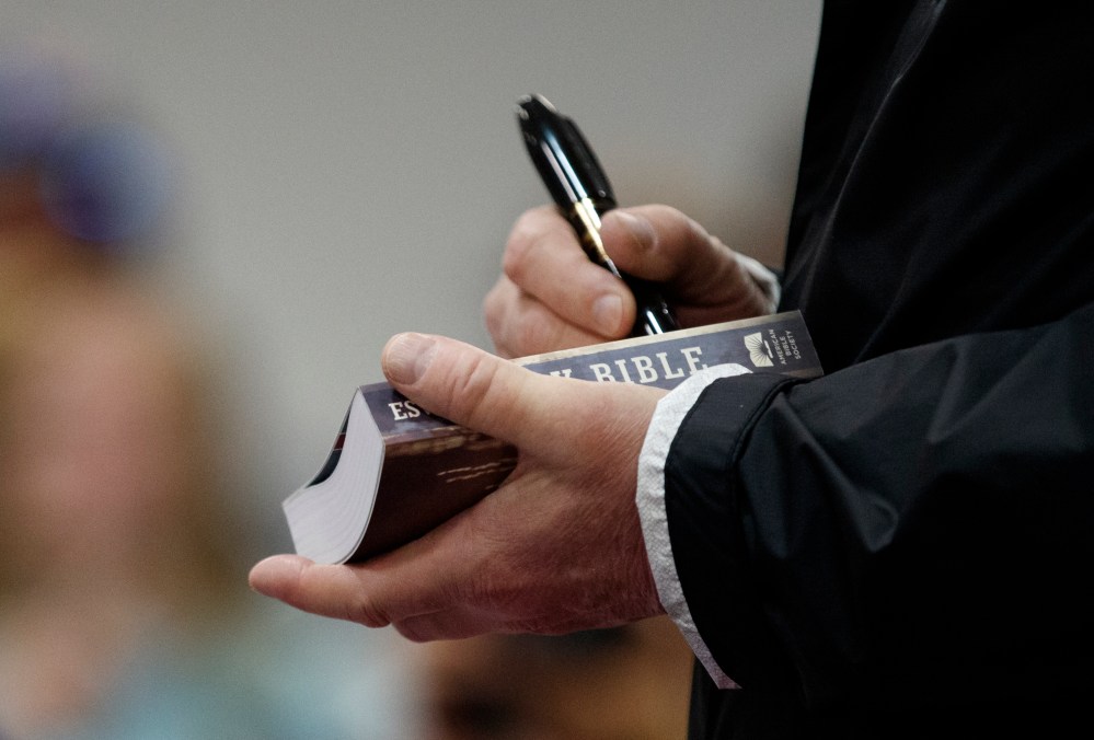 President Donald Trump signs a Bible as he greets people at Providence Baptist Church in Smiths Station, Ala., Friday, March 8, 2019, as they travel to tour areas where tornados killed 23 people in Lee County, Ala.