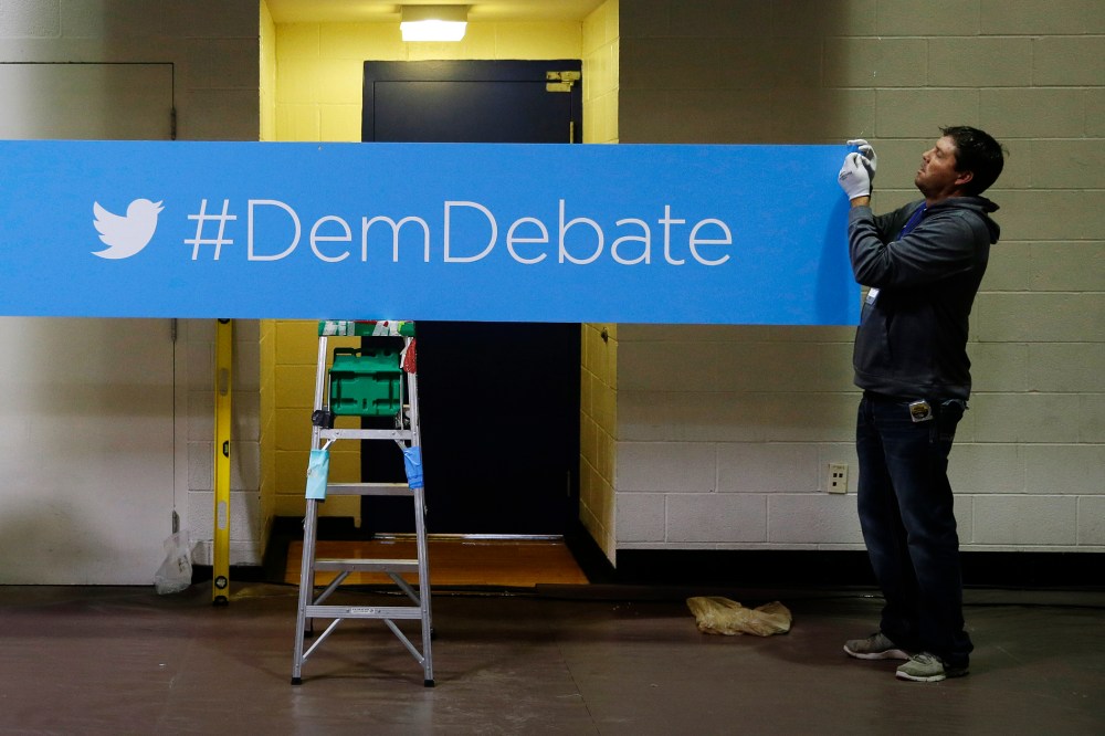 A sign for the Democratic debate hashtag is hung in the media filing center before the Nov. 13, 2015 Democratic Presidential Debate in Des Moines, Iowa. (Photo by Charlie Neibergall/AP)