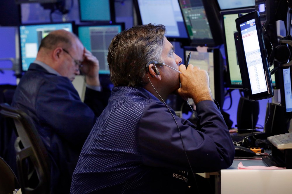 Traders work in a booth on the floor of the New York Stock Exchange, Aug. 24, 2015. (Photo by Richard Drew/AP)