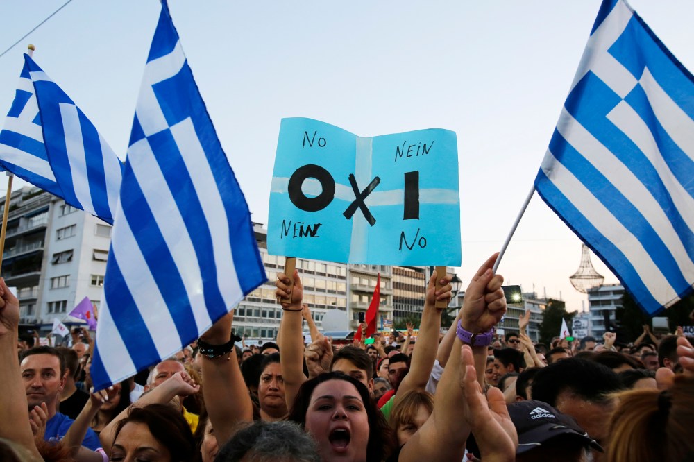 A demonstrator holds a placard reading in Greek, German and English the word ''NO'' during a rally organized by supporters of the No vote in Athens on July 3, 2015. (Photo by Petros Karadjias/AP)