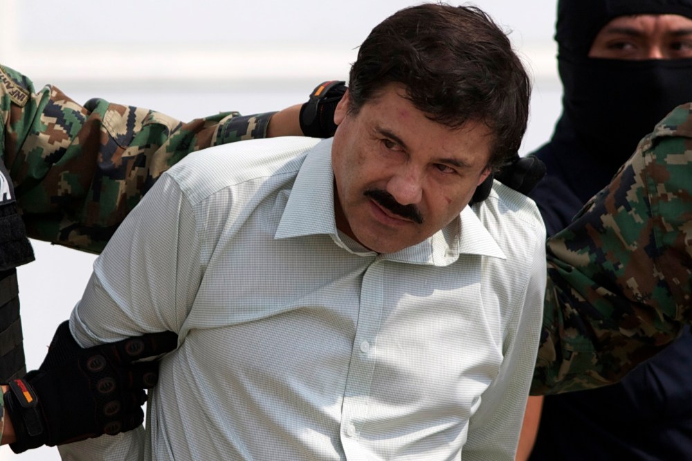 Joaquin "El Chapo" Guzman is escorted to a helicopter in handcuffs by Mexican navy marines at a navy hanger in Mexico City, Feb. 22, 2014. (Photo by Eduardo Verdugo/AP)