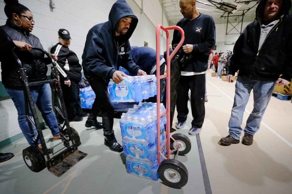 Will Burnett helps load a cart with bottled water at the Salvation Army Flint Beecher Corps Community Center in Flint, Mich., Jan. 26, 2016. (Photo by Carlos Osorio/AP)
