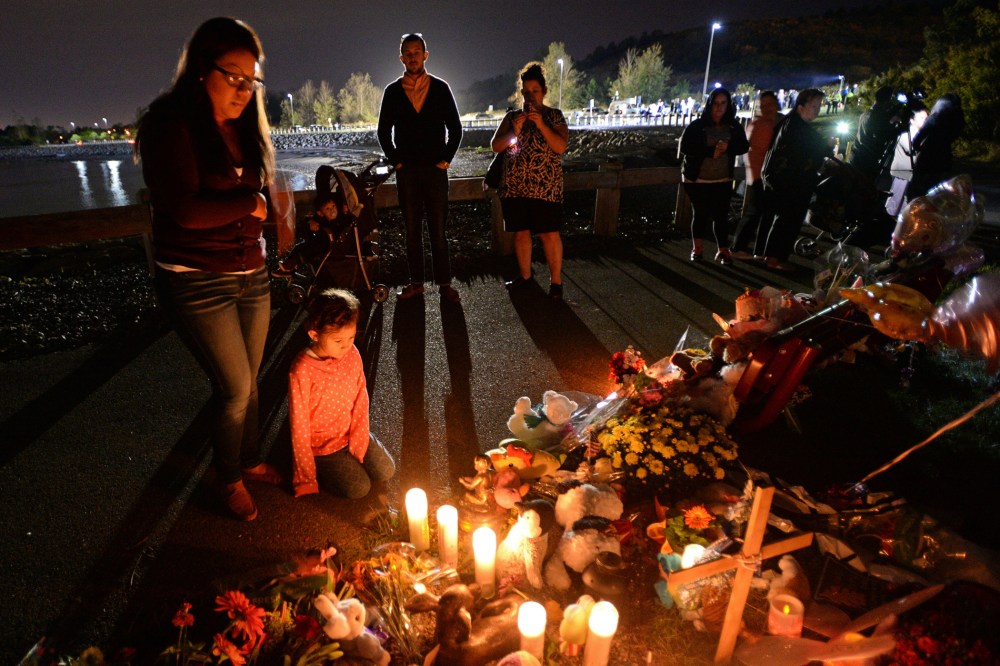 People attend a candlelight vigil for Bella Bond on Deer Island in Boston on Sept. 21, 2015. (Photo by Christopher Evans/The Boston Herald/AP)