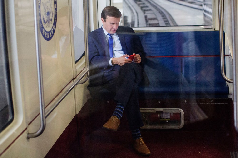 Sen. Chris Murphy, D-Conn., uses his cell phone as he rides the Senate subway in Washington, D.C., Dec. 1, 2015. (Photo By Al Drago/CQ Roll Call/AP)