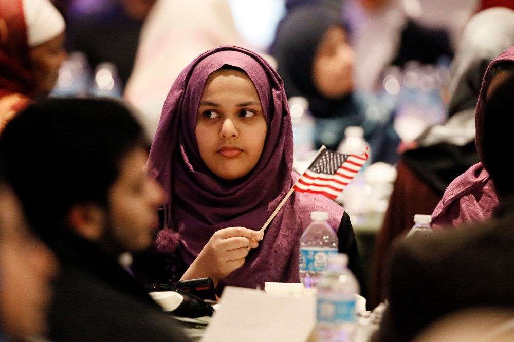 A young woman waves an American flag along with others at the beginning of a Muslim conference against terror and hate at the Curtis Culwell Center, Saturday, Jan. 17, 2015, in Garland, Tex. (Photo by Tony Gutierrez/AP)