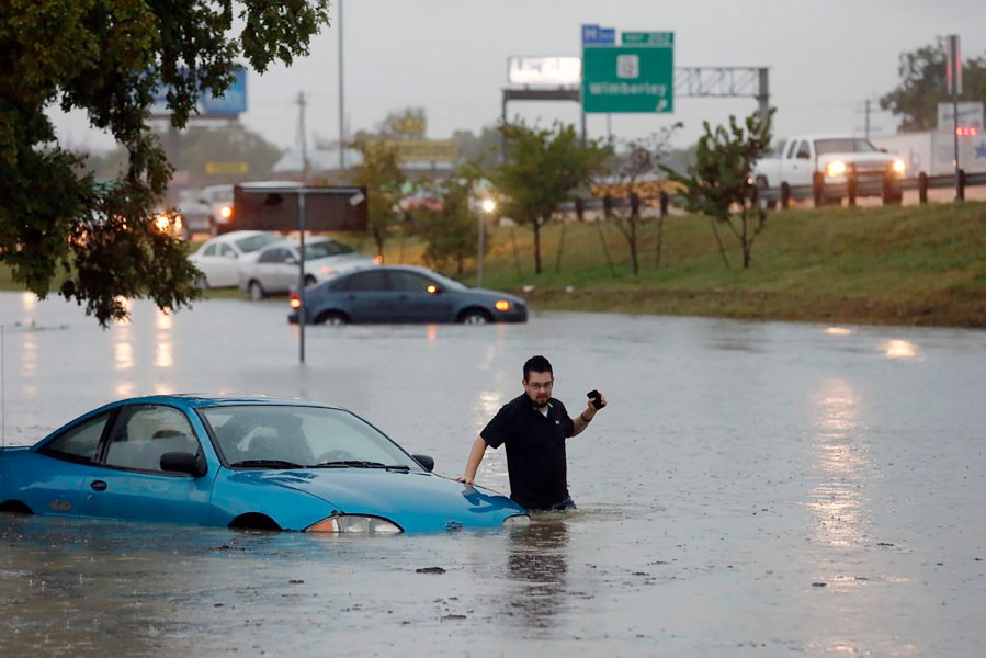 Mike Stoner gets out of his flooded car, Friday, Oct. 30, 2015 in San Marcos, Texas. (Photo by Rodolfo Gonzalez/Austin American-Statesman/AP)