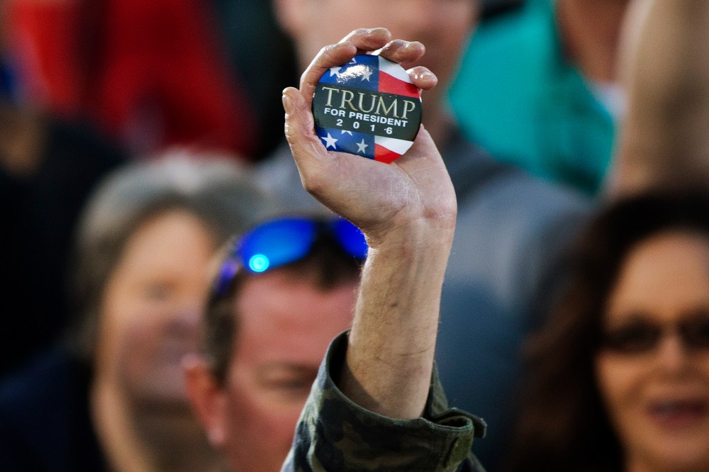 A man holds up a campaign button for Republican presidential candidate Donald Trump during a rally, Feb. 28, 2016, in Madison, Ala. (Photo by John Bazemore/AP)