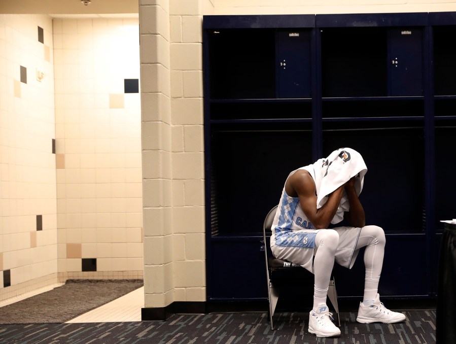 North Carolina's Theo Pinson sits in the locker room after the NCAA Final Four tournament college basketball championship game against Villanova, April 4, 2016, in Houston. (Photo by Eric Gay/AP)