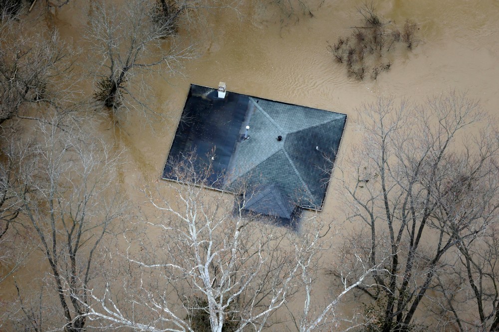 In this aerial photo, floodwater reaches the rooftop of a house, Dec. 31, 2015, in Valley Park, Mo. (Photo by Jeff Roberson/AP)