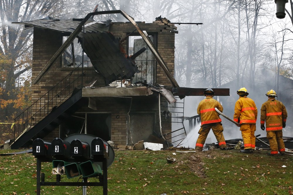 Firefighters work at the scene where authorities say a small business jet crashed into an apartment building in Akron, Ohio, Tuesday, Nov. 10, 2015. (Photo by Ed Suba Jr./Akron Beacon Journal/AP)