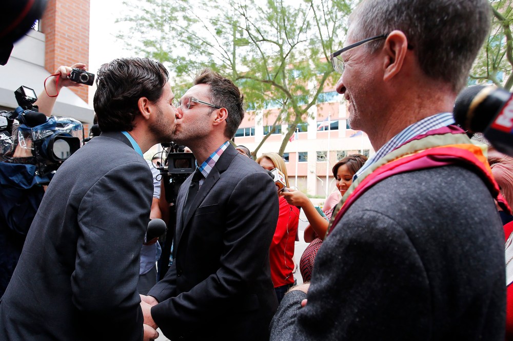 Kevin Patterson, left, and David Larance kiss after exchanging vows, as Rev. John Dorhaer, who performed the ceremony, stands at right, on Oct. 17, 2014, in Phoenix, Ariz.