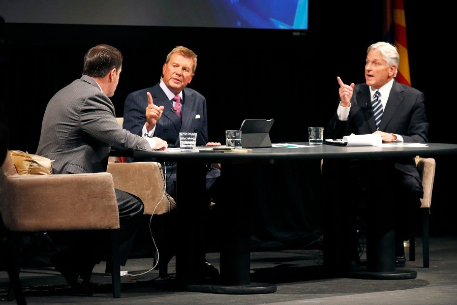 Republican Doug Ducey, left, and Democrat Fred DuVal, right, with moderator John Hook during a gubernatorial debate on Sept. 28, 2014, in Phoenix, Ariz.