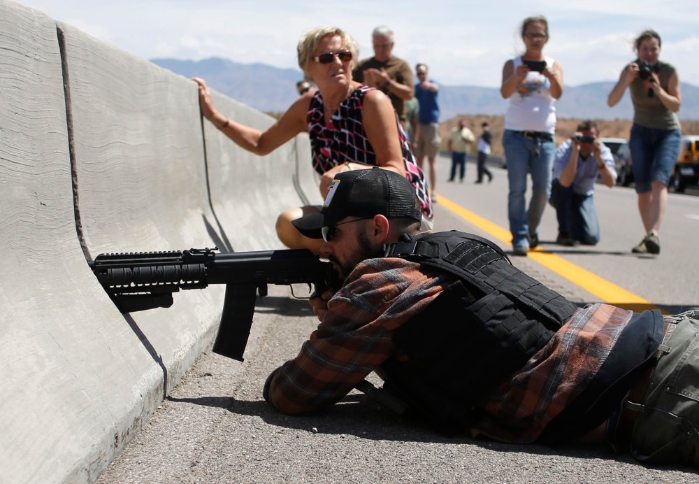 Protester Eric Parker aims his weapon next to the Bureau of Land Management's base camp where seized cattle are being held near Bunkerville, Nevada, April 12, 2014.