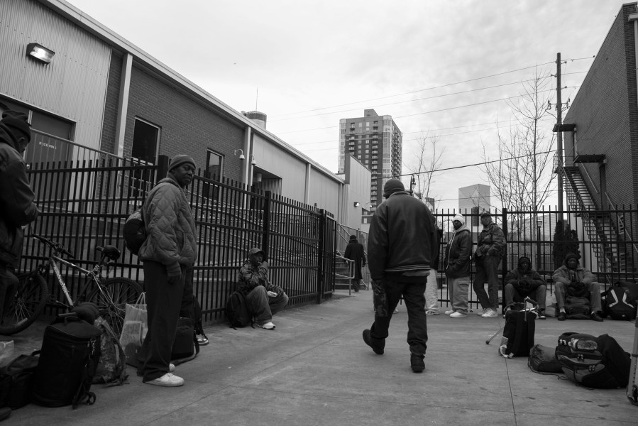 Homeless men line up in the courtyard of The Shepherd’s Inn men’s shelter in Atlanta, Georgia, waiting to get assigned a bed for the night.