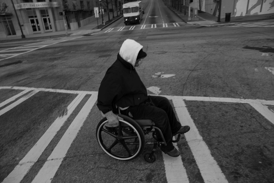 Donn Smith, makes his way up a hill to the CNN Center in Atlanta to get a coffee. 45 and homeless, Donn, born Dong in Vietnam, is the son of an American G.I. and a Vietnamese women. He is wheelchair bound due to Polio. He said that if there are budget cut