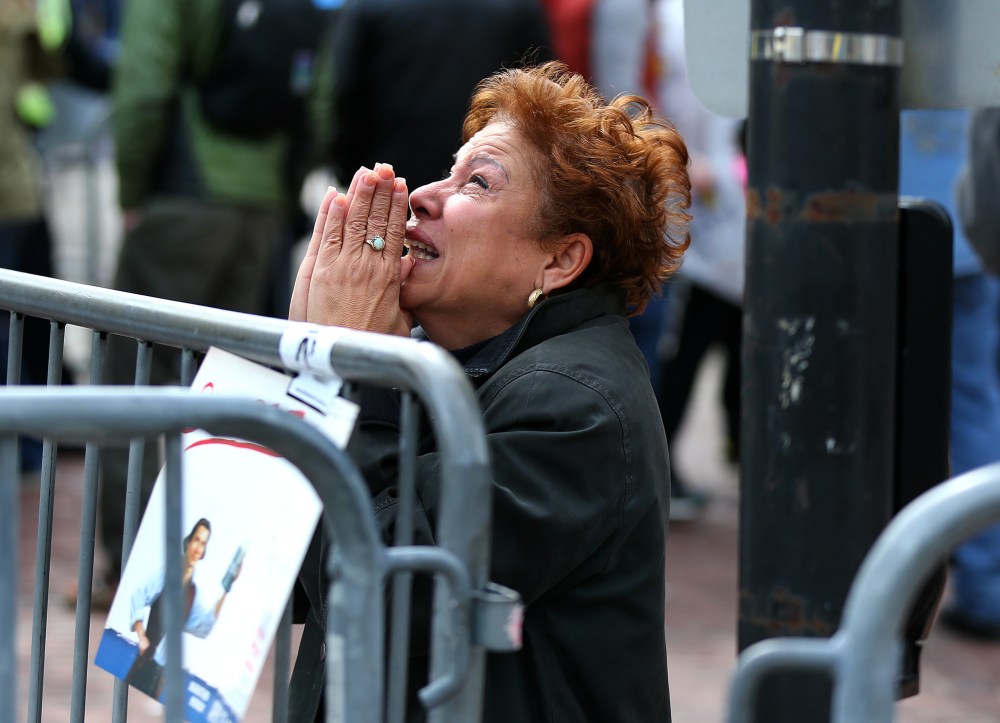 BOSTON - APRIL 15: A woman kneels and prays at the scene of the first explosion on Boylston Street near the finish line of the 117th Boston Marathon on April 15, 2013. (Photo by John Tlumacki/The Boston Globe via Getty Images)