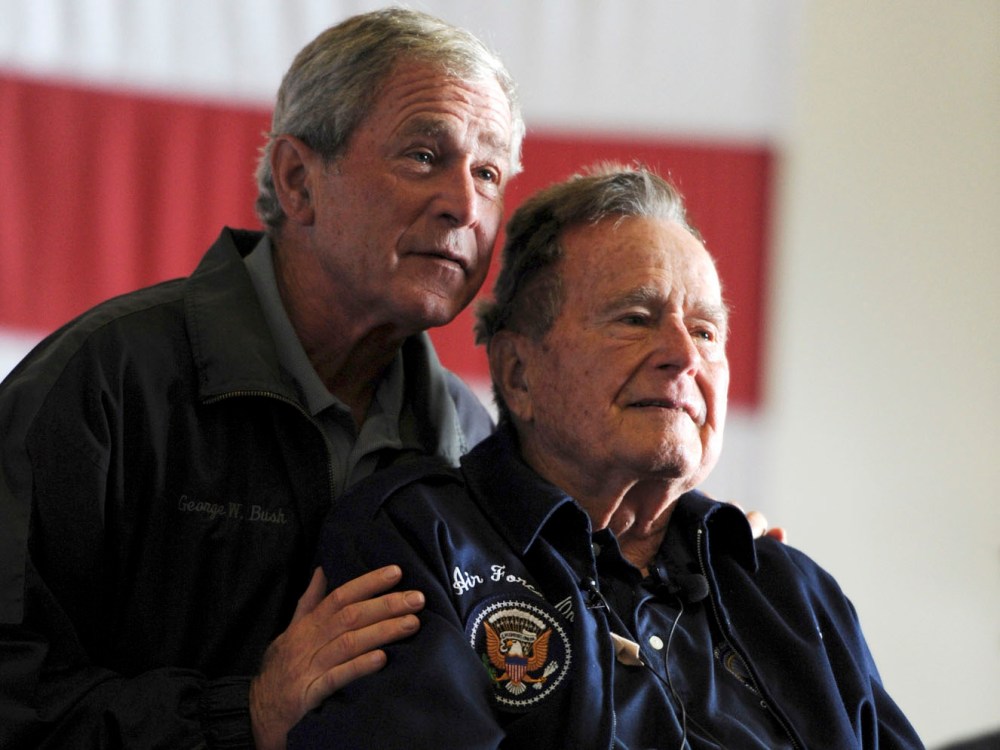 Former Presidents George W. Bush, (L) and George H.W. Bush deliver remarks to the crew during a ceremony aboard the aircraft carrier USS George H.W. Bush (CVN 77) during a promotion and reenlistment ceremony in the Atlantic Ocean in this handout photo...