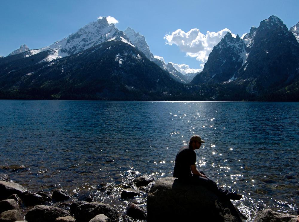 A hiker takes a break on the shore of Jenny Lake in Grand Teton National Park Tuesday, June 1, 2004.