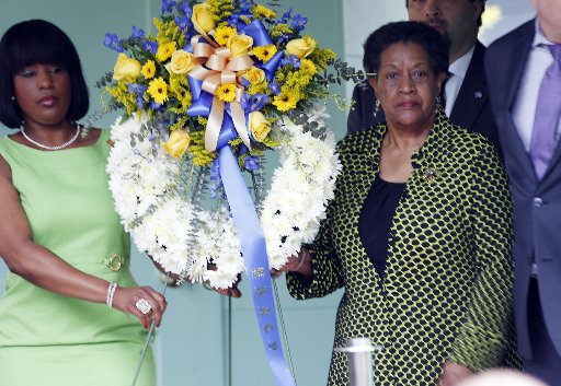 Myrlie Evers-Williams, widow of Medgar Evers, right and Roslyn M. Brock, chairwoman of the NAACP national board of directors, left, carry the wreath to be placed in front of the former home of the slain civil rights leader, Thursday, May 16, 2013, in...
