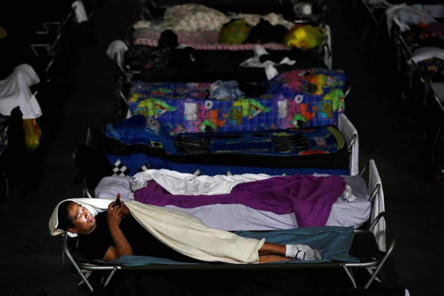 An evacuee from the Fort McMurray wildfires checks his phone at the 