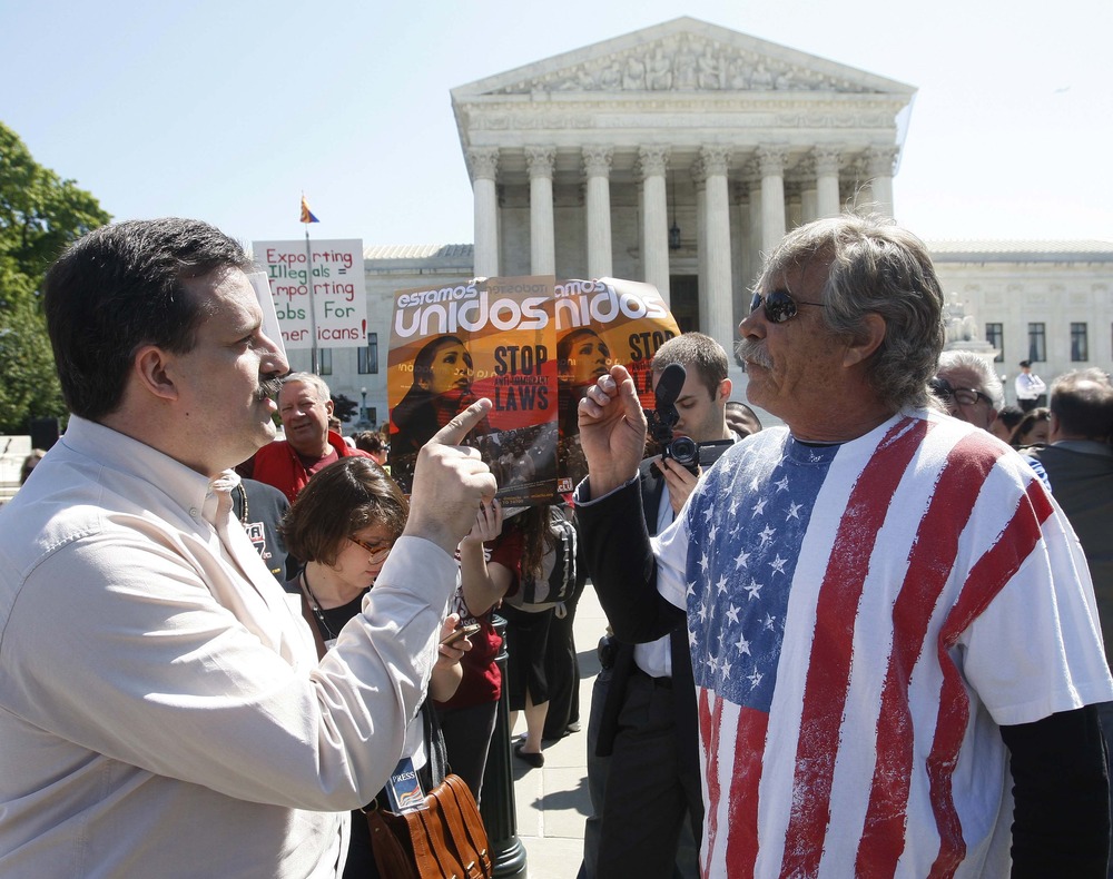 A supporter and an opponent of Arizona's immigration law argue outside the U.S. Supreme Court.