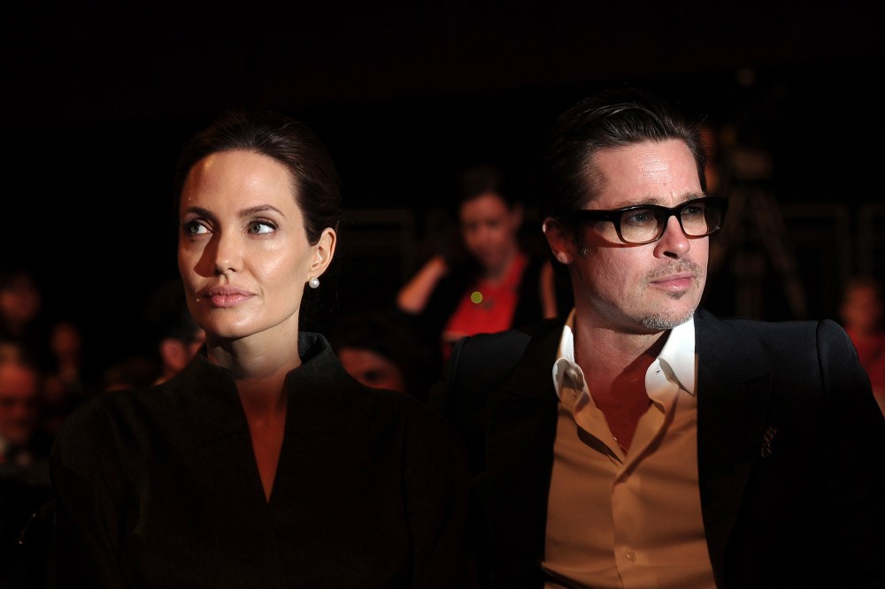 Angelina Jolie (L) and her husband Brad Pitt attend the fourth day of the Global Summit to End Sexual Violence in Conflict in London on June 13, 2014. (Photo by Carl Court/AFP/Getty)