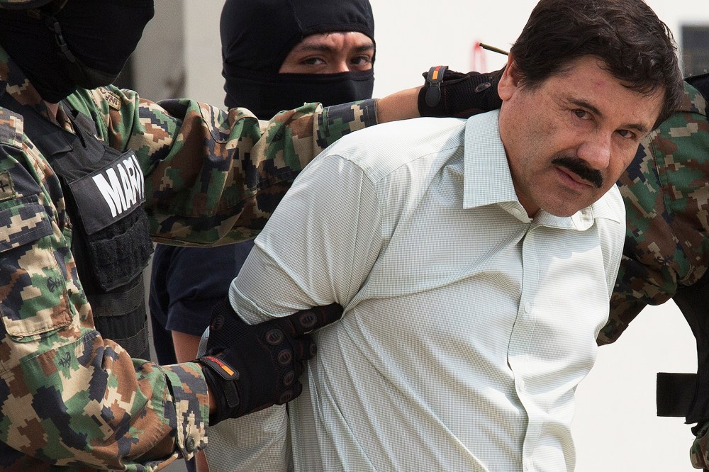 Drug trafficker Joaquin "El Chapo" Guzman is escorted to a helicopter by Mexican security forces at Mexico's International Airport in Mexico city, Mexico on Feb. 22, 2014. (Photo by Susana Gonzalez/Bloomberg/Getty)