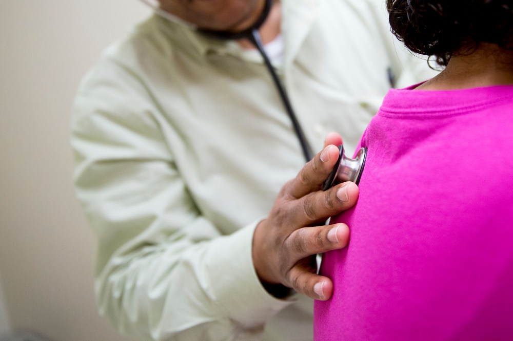A family practice provider uses a stethoscope to examine a patient in an exam room. (Photo by Andrew Harrer/Bloomberg/Getty)