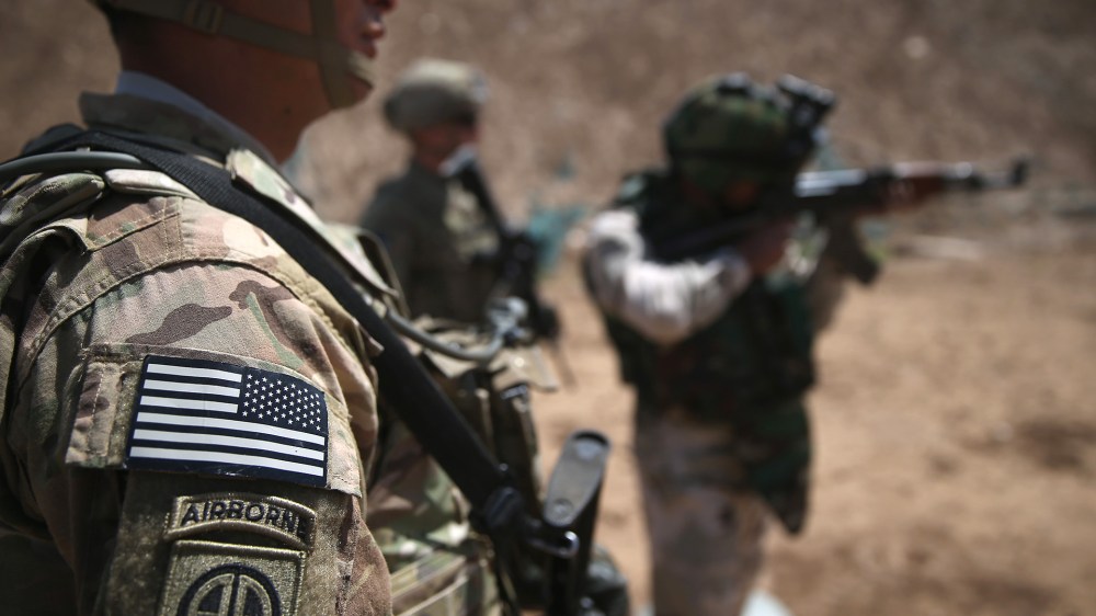 U.S. Army trainers watch as an Iraqi recruit fires at a military base on April 12, 2015 in Taji, Iraq. (Photo by John Moore/Getty)