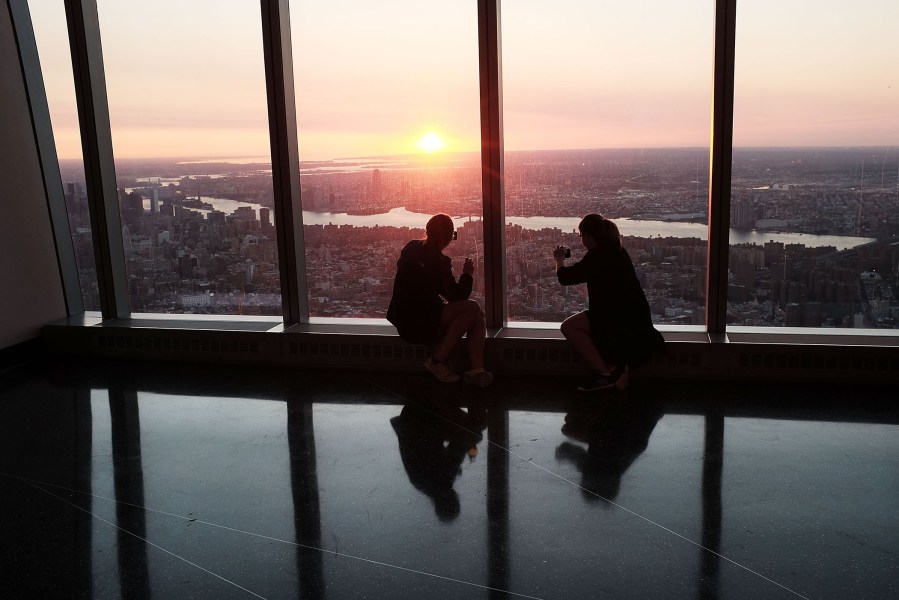 People view the sunrise at the newly built One World Observatory at One World Trade Center on the day it opens to the public on May 29, 2015 in New York, N.Y.
