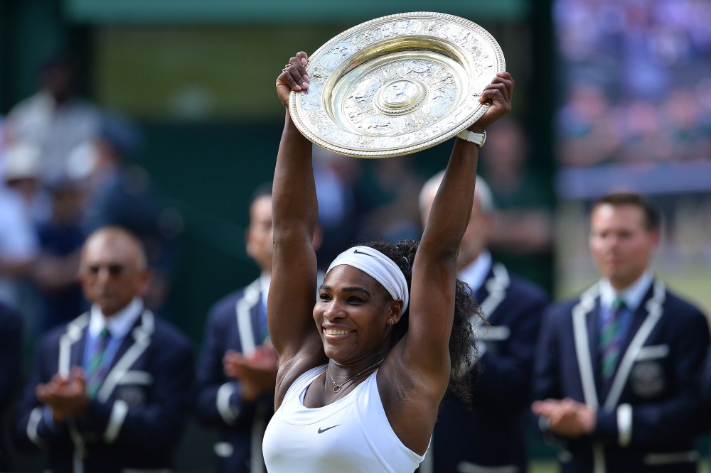 US player Serena Williams celebrates with the winner's trophy, the Venus Rosewater Dish, after her women's singles final victory over Spain's Garbine Muguruza during the 2015 Wimbledon Championships on July 11, 2015. (Photo by Glyn Kirk/AFP/Getty)
